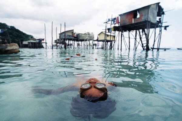 Ein Bajau-Kind schwimmt im Wasser, während es in einem Bajau-Dorf auf der Insel Timbun Mata in Semporna spielt. Bild aus der Story: „Die Bajau: Ein Leben auf dem Wasser“ (Malaysia), Foto und Bericht: Aizuddin Saad